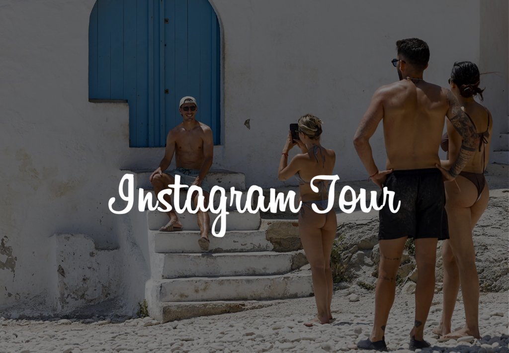 Tour de Instagram en Santorini: grupo de turistas fotografiando a amigo en escaleras de iglesia blanca con puerta azul