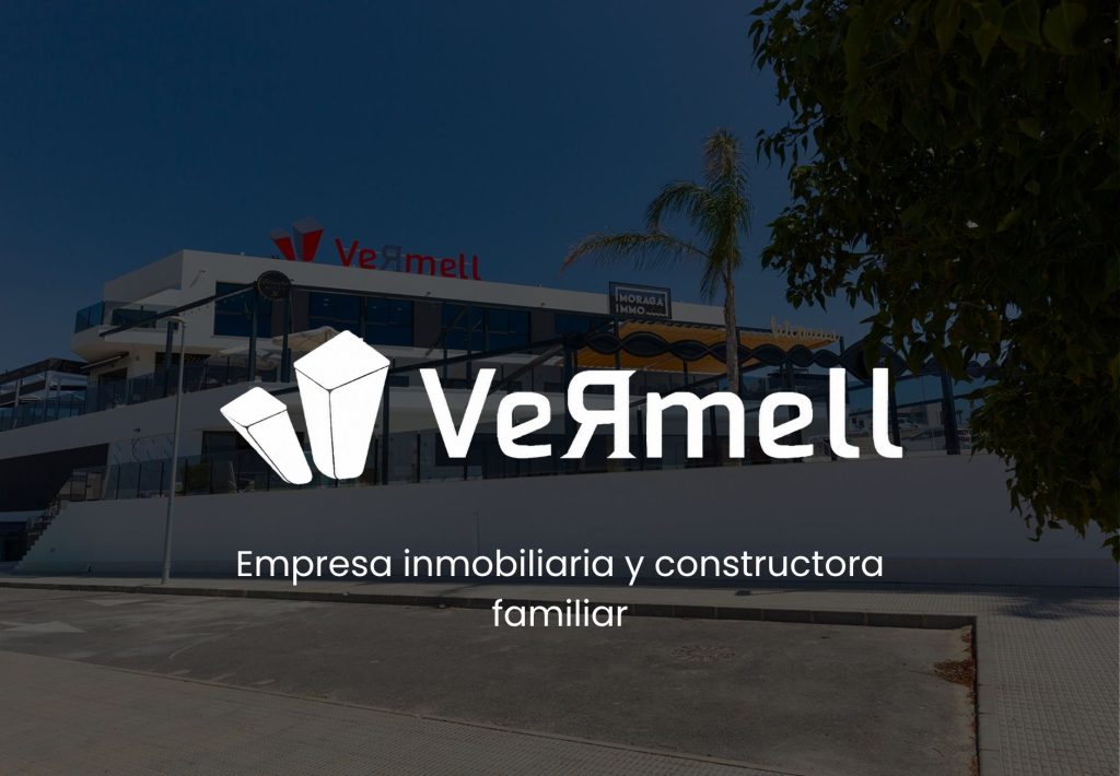 Logo de Vermell, empresa inmobiliaria y constructora familiar, con sede moderna al fondo