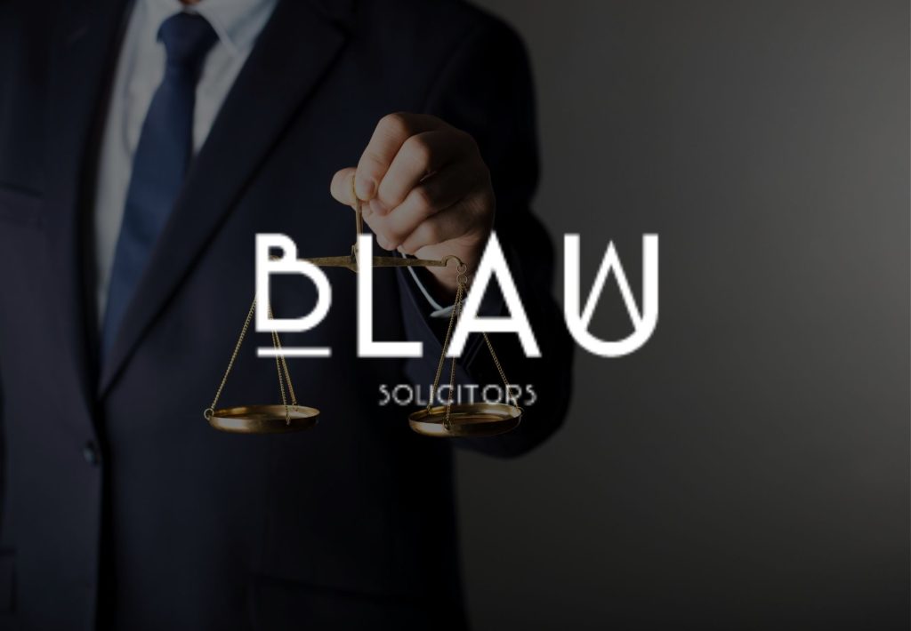 Abogado sosteniendo balanza de justicia con logo BLAW Solicitors, firma de abogados profesional
