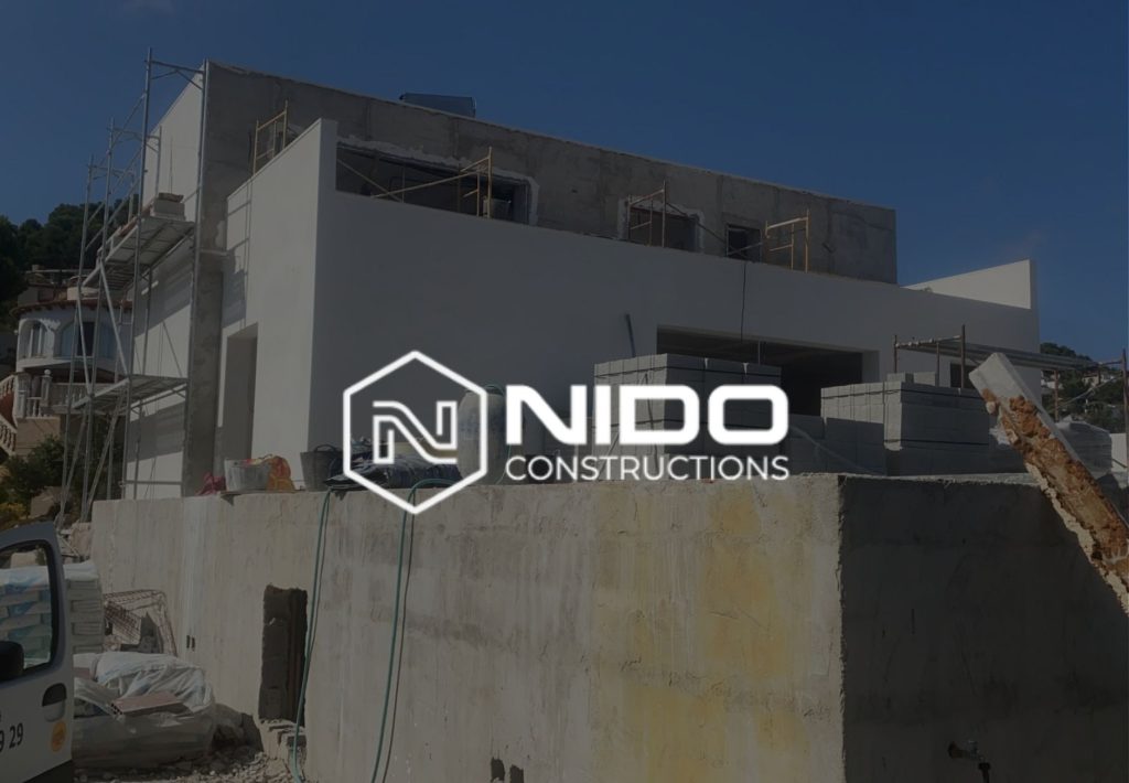 Construcción de villa moderna en proceso con andamios y logo de Nido Constructions, obra en exterior