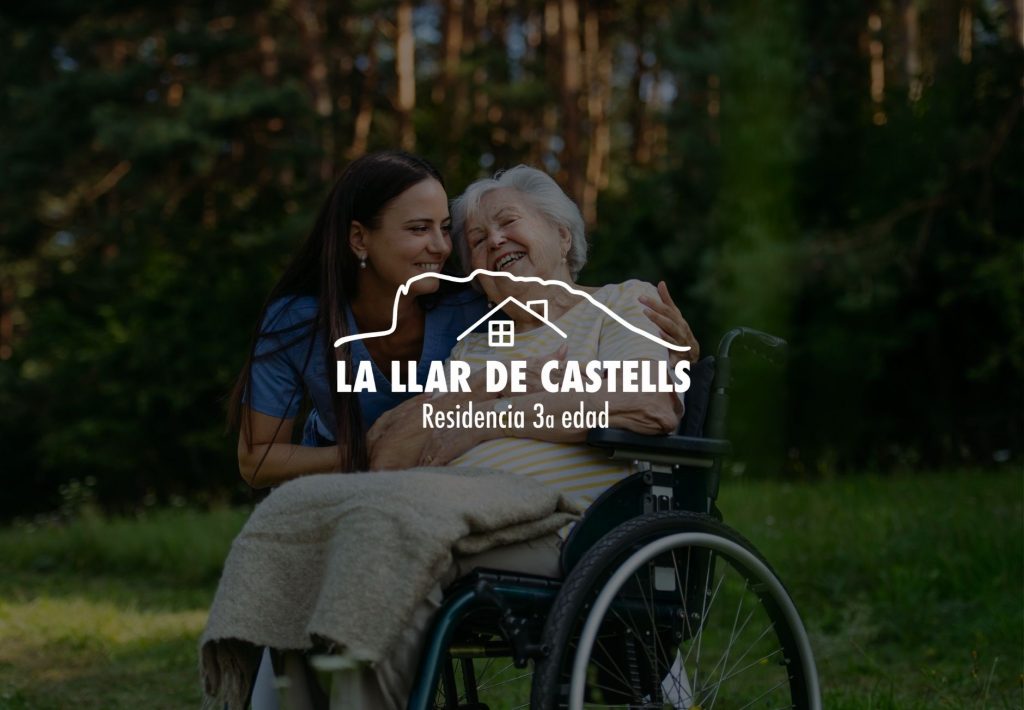 Residencia de tercera edad La Llar de Castells: cuidadora abrazando a anciana en silla de ruedas en jardín