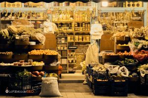 Puesto de mercado turco con frutas, verduras, encurtidos y productos tradicionales del campo iluminado de noche