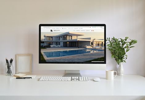 Sitio web de arquitecto Pedro en iMac mostrando villa moderna con piscina, diseño arquitectónico de lujo