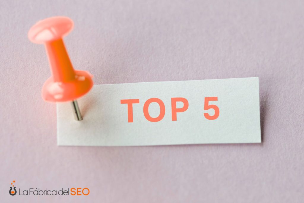 Chincheta naranja sobre nota con texto TOP 5, representando los mejores resultados GEO en posicionamiento SEO