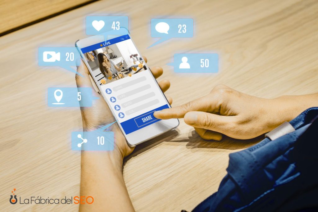 Manos sosteniendo smartphone con transmisión en vivo y métricas de redes sociales: likes, comentarios y seguidores