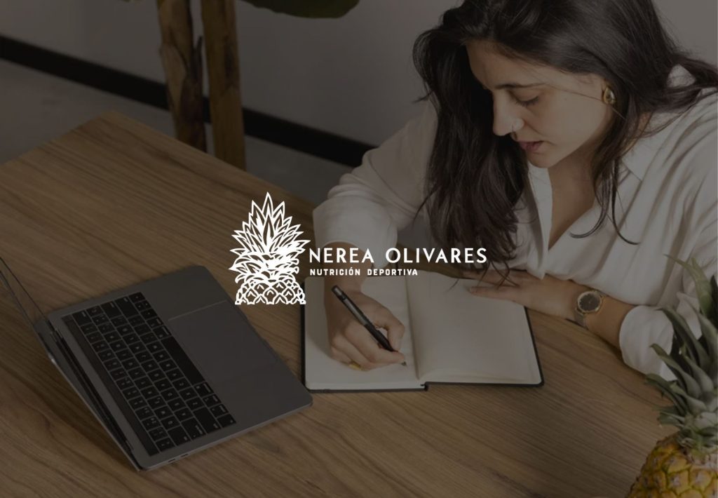 Nerea Olivares nutricionista deportiva tomando notas en cuaderno junto a portátil y piña fresca