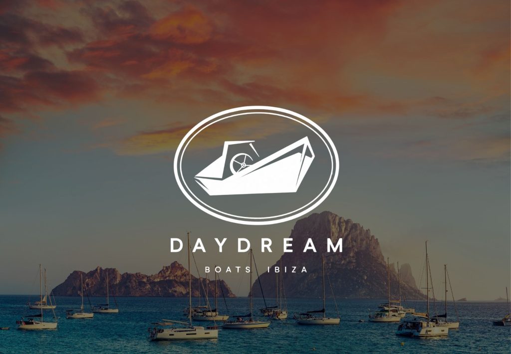 Logo de Daydream Boats Ibiza con veleros anclados frente a Es Vedrà al atardecer