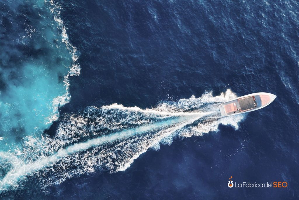 Lancha motora de lujo navegando a alta velocidad vista aérea en aguas azules del mar Mediterráneo