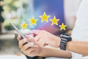 Persona valorando reseñas con 5 estrellas en smartphone, simbolizando la importancia de las opiniones online
