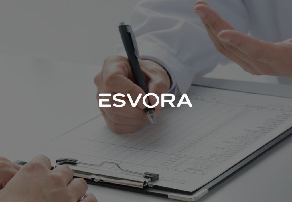 Logotipo de Esvora sobre fondo con manos firmando documentos en portapapeles durante consulta profesional