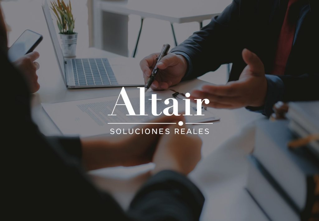 Reunión de negocios con firma de contrato y logo de Altair Soluciones Reales al frente