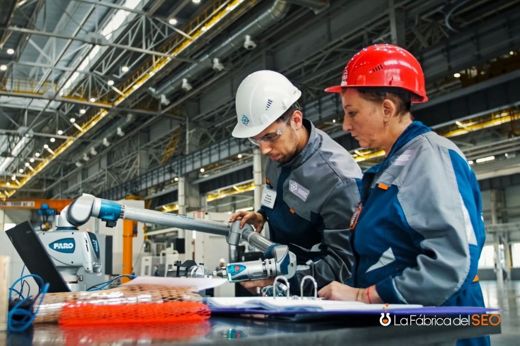 Ingenieros industriales con cascos de seguridad usando brazo de medición FARO en planta de fabricación