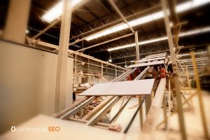Línea de producción en fábrica cerámica B2B con placas cerámicas en cinta transportadora industrial