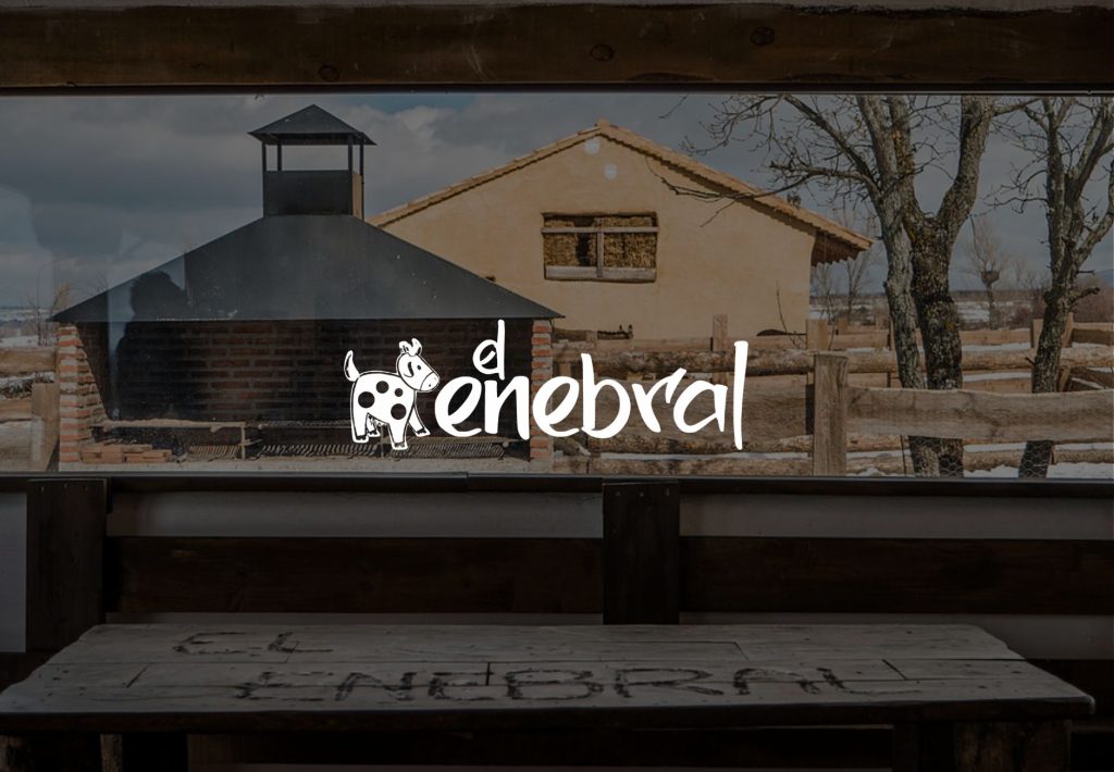 Logo de El Enebral sobre vista de granja rural castellana con barbacoa de ladrillo y edificio de adobe en invierno