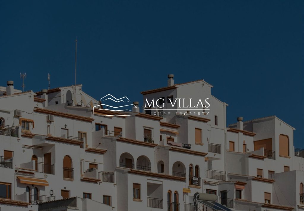 Logo de MG Villas Luxury Property sobre fachada de villas de lujo blancas con arquitectura mediterránea en España