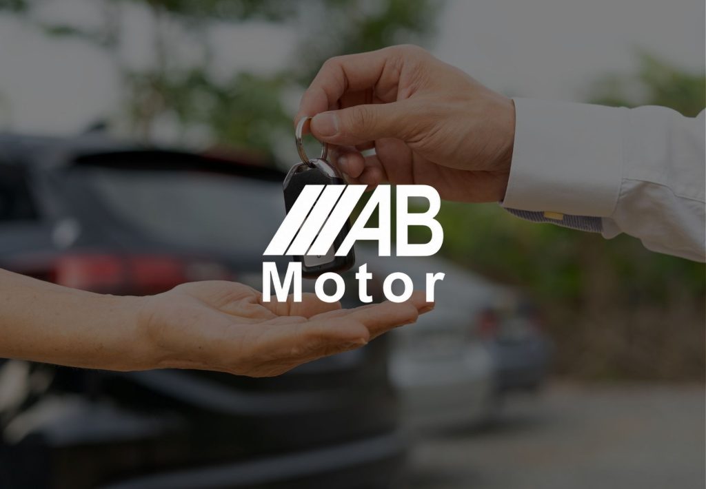 Logotipo de AB Motor sobre escena de entrega de llaves de coche entre vendedor y comprador en concesionario